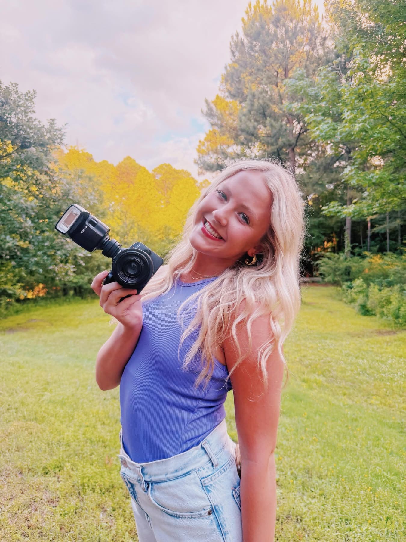 Gracie K, the photographer behind Photos By Gracie K, holding her camera